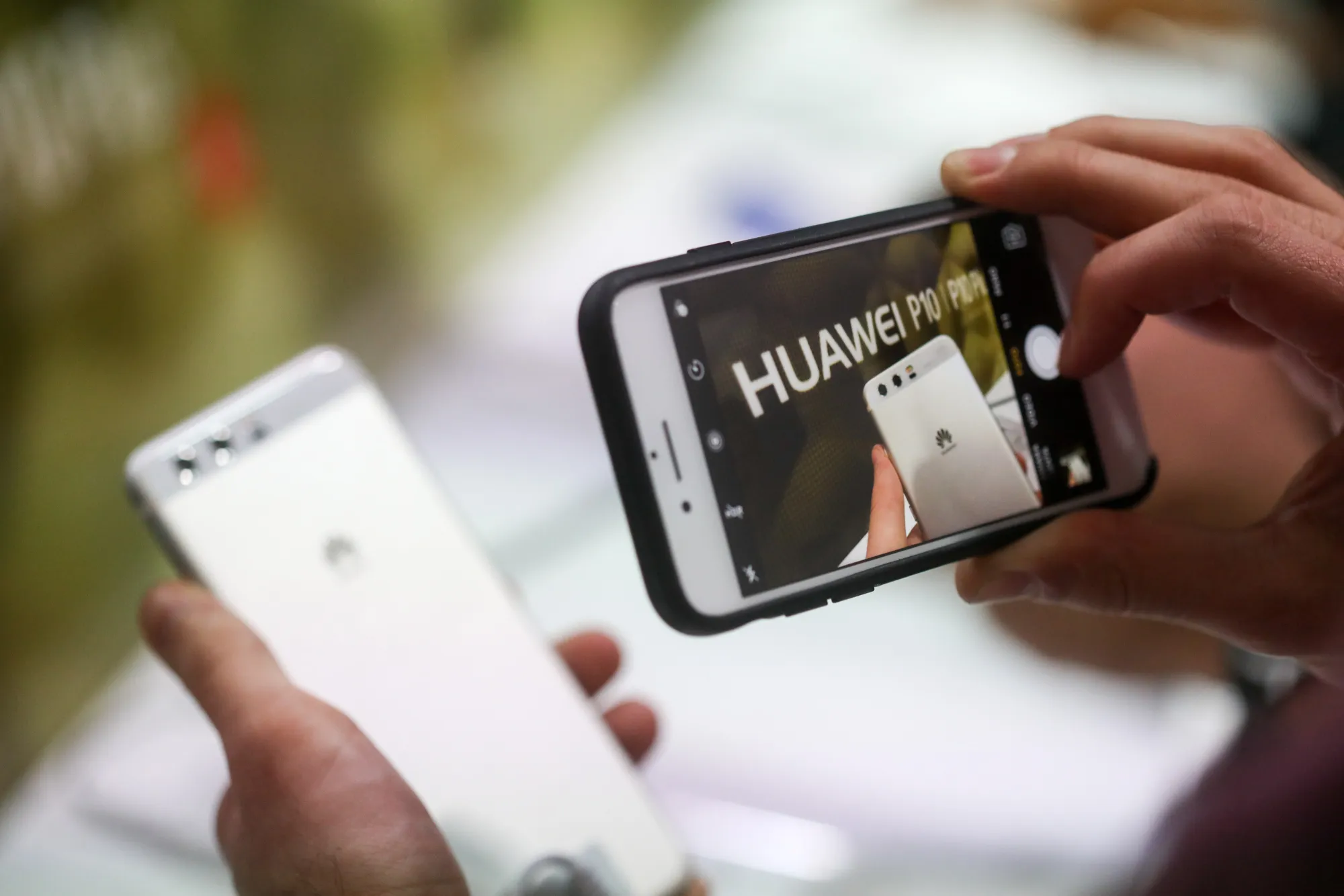 An attendee uses a smartphone to take a photograph of a P10 smartphone, manufactured by Huawei Technologies Co Ltd., during its launch ahead of the Mobile World Congress (MWC) in Barcelona, Spain, on Sunday, Feb. 26, 2017.