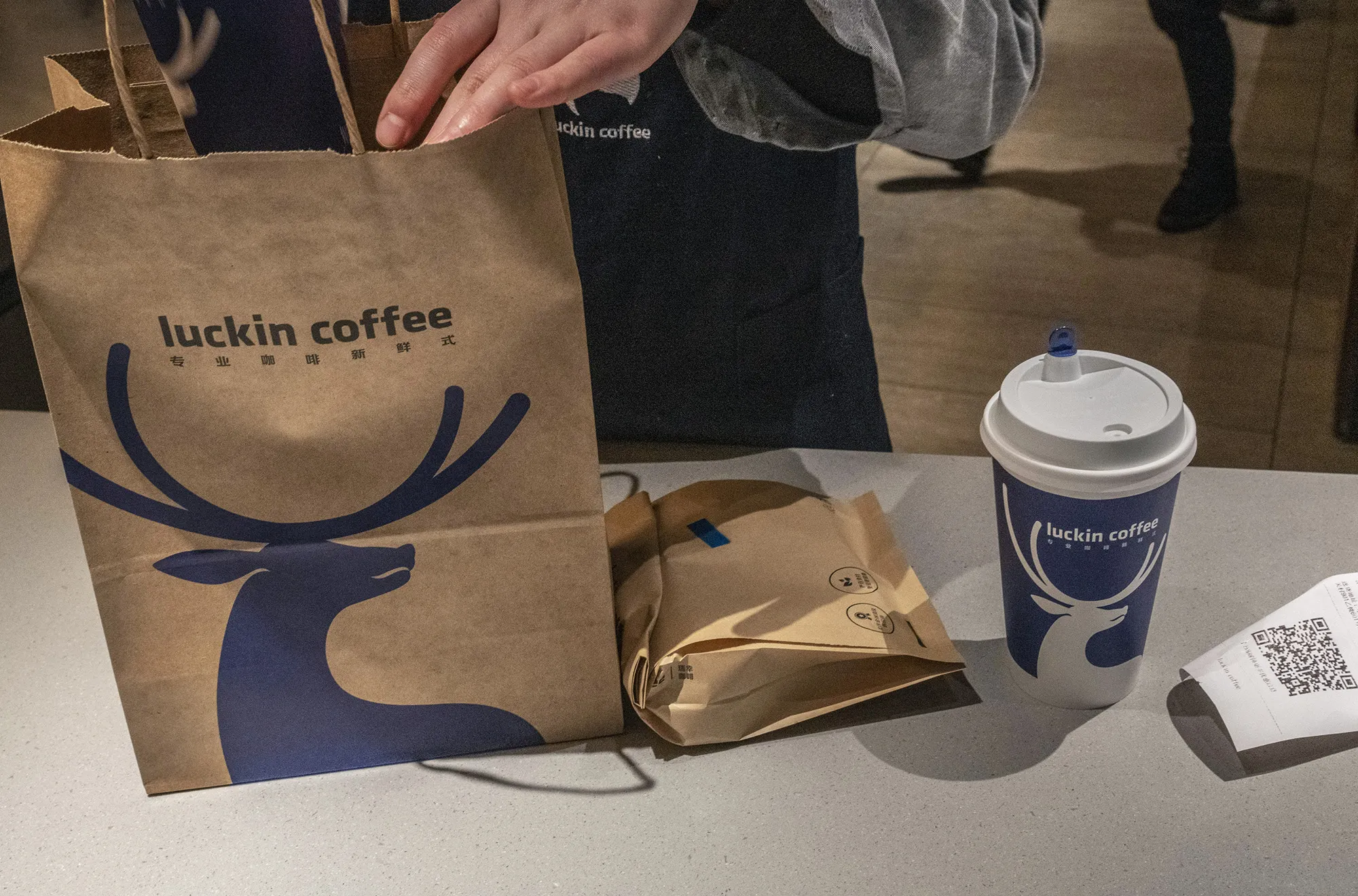 An employee prepares a customer's take-away order at a Luckin Coffee outlet in Beijing.