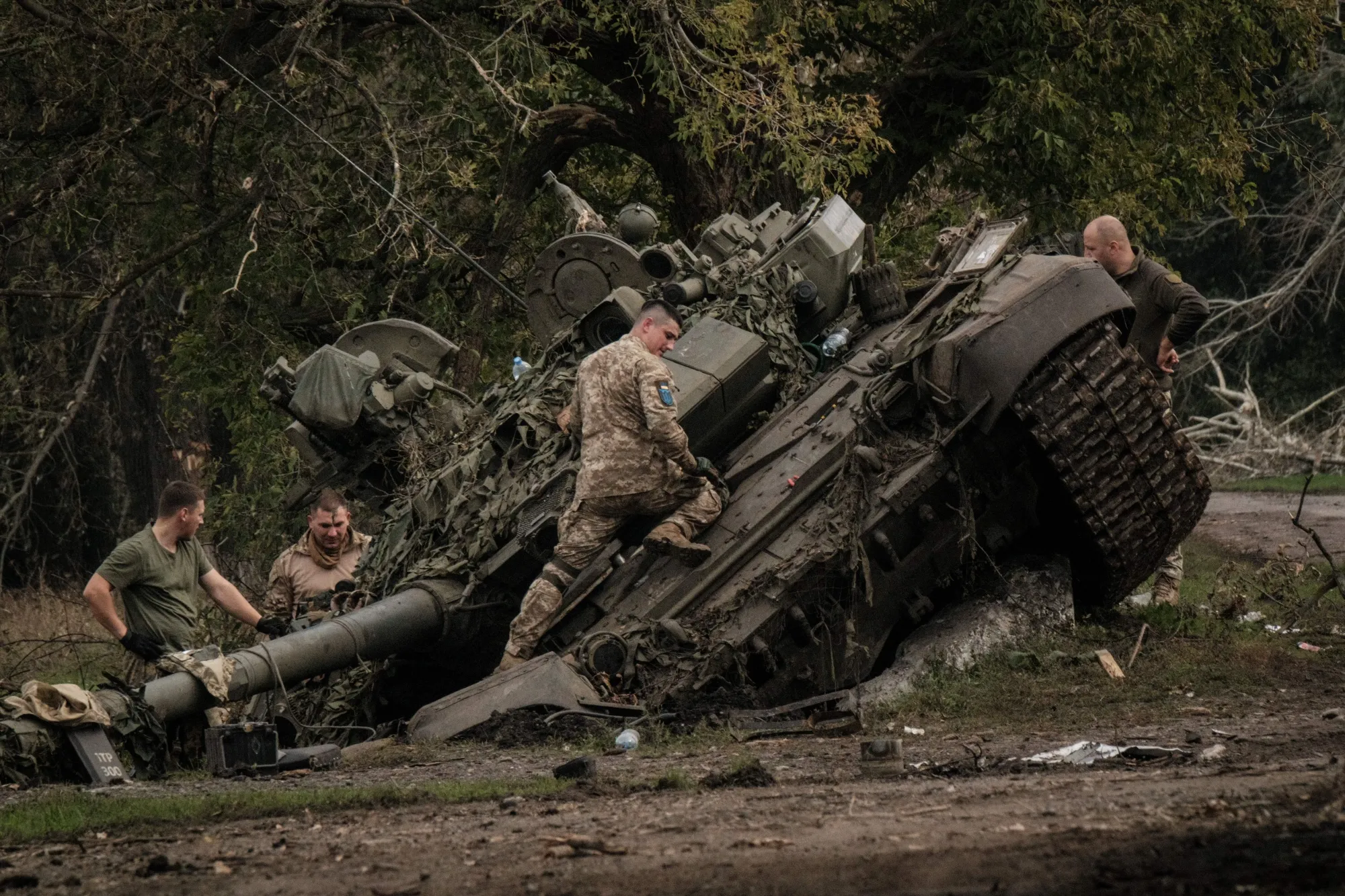 Ukrainian soldiers examine an abandoned Russian T-90&nbsp;tank in Kyrylivka, near Kharkiv.