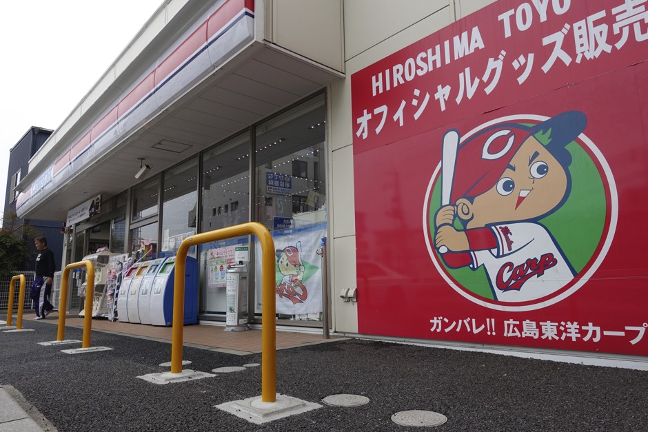 “Carp Boya (boy),” a mascot character for the homegrown baseball club, Hiroshima Toyo Carp, is on display in a poster announcing the sale of official goods at a convenience store near the team’s home stadium in Hiroshima, western Japan.