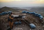 An Afghan militia fighter keeps watch at an outpost against Taliban insurgents at Charkint district in Balkh Province, on July 11. 
