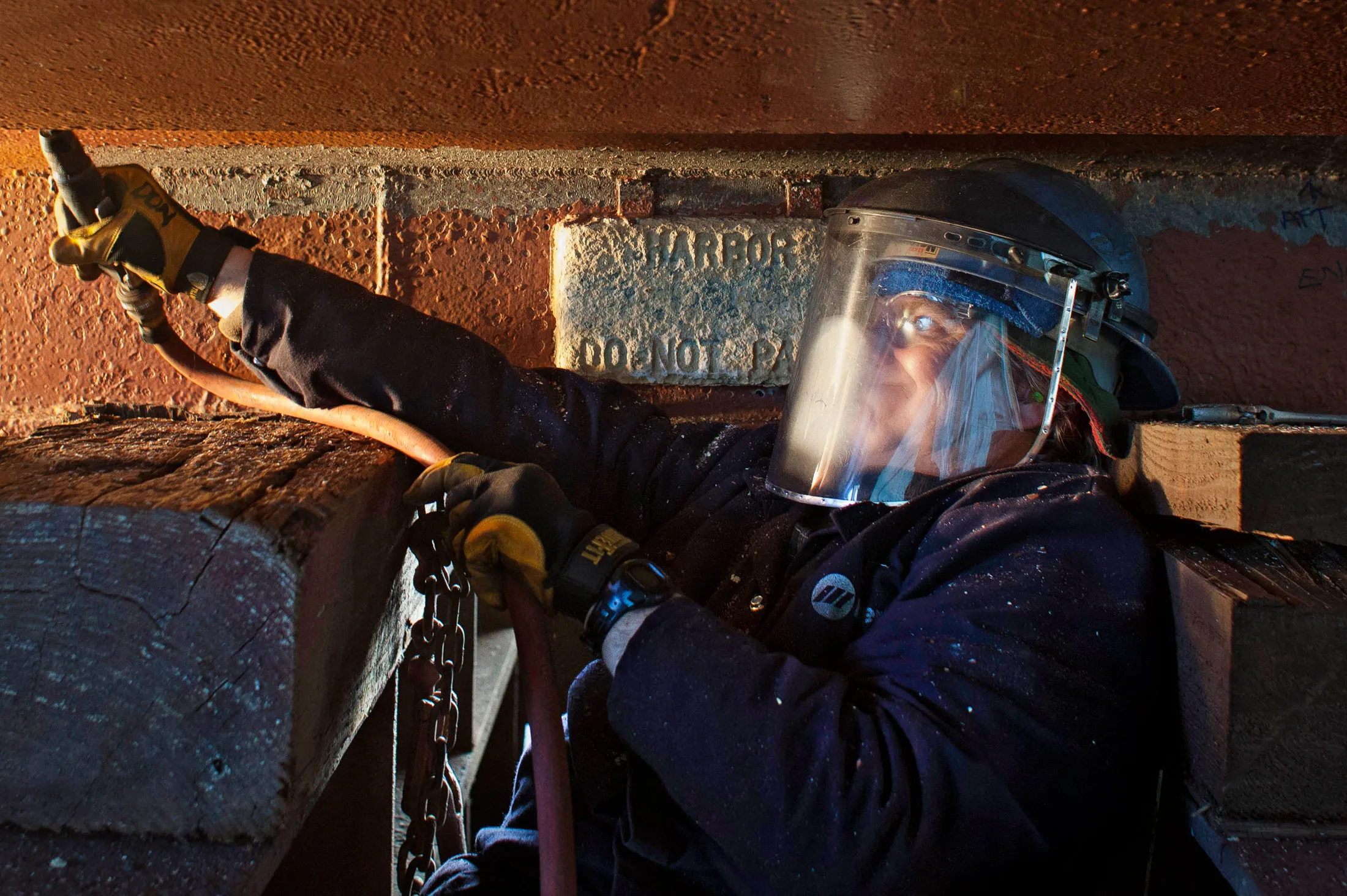 An employee repairs the hull of an Alaskan fishing vessel at the Pacific Fishermen Shipyard in Seattle, Washington, U.S.
