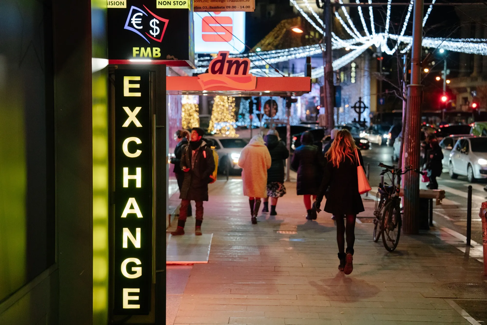 Pedestrians pass a currency exchange bureau in Bucharest.