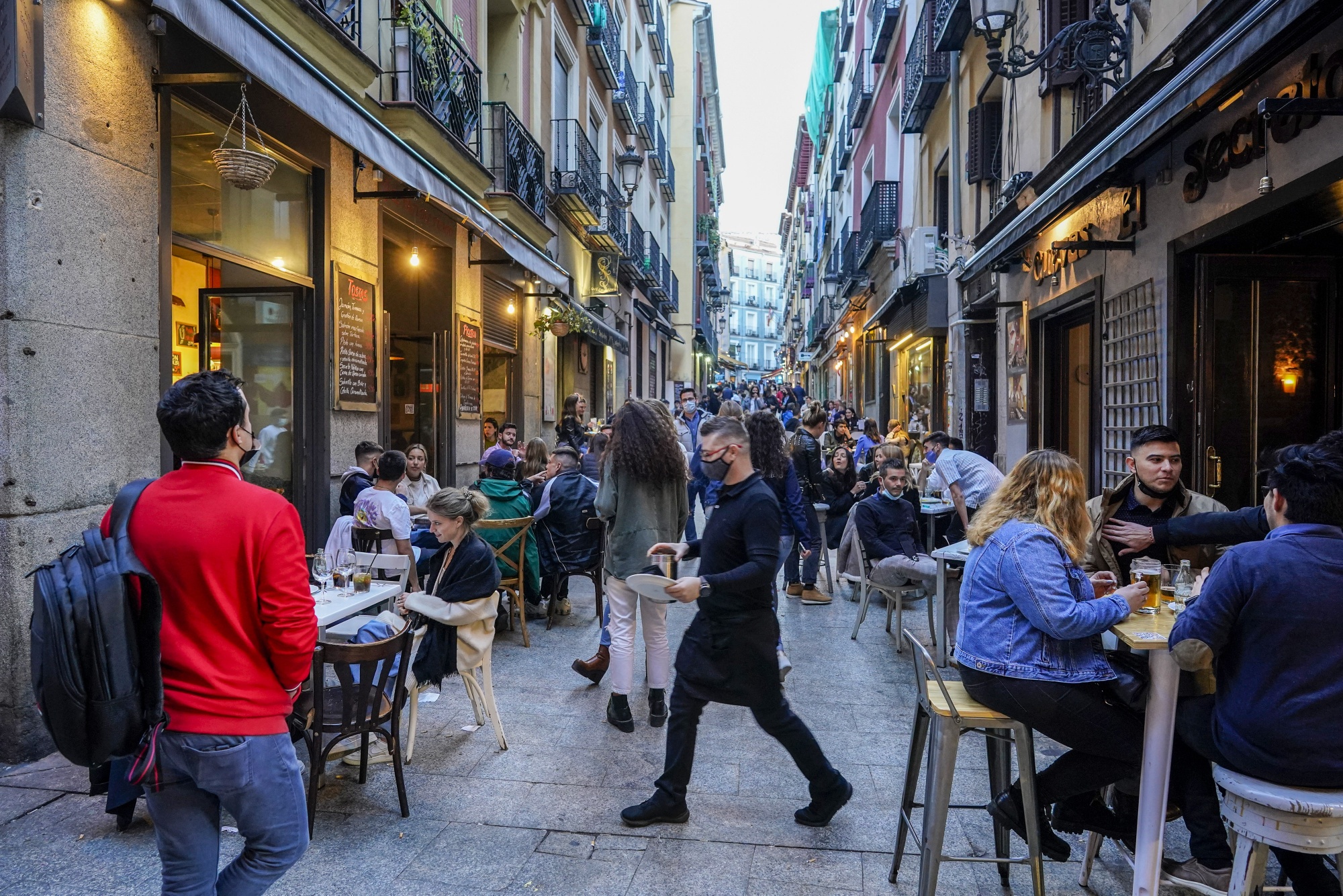 Customers eat and drink&nbsp;outside bars in Madrid, Spain.