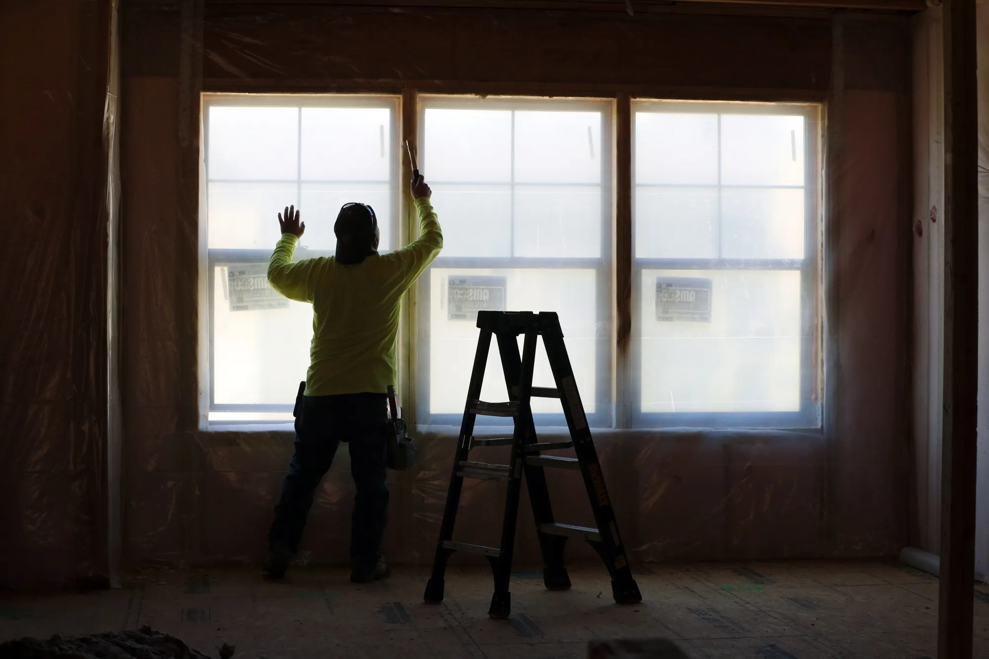 A contractor installs wall insulation in a home under construction in Park City, Utah.