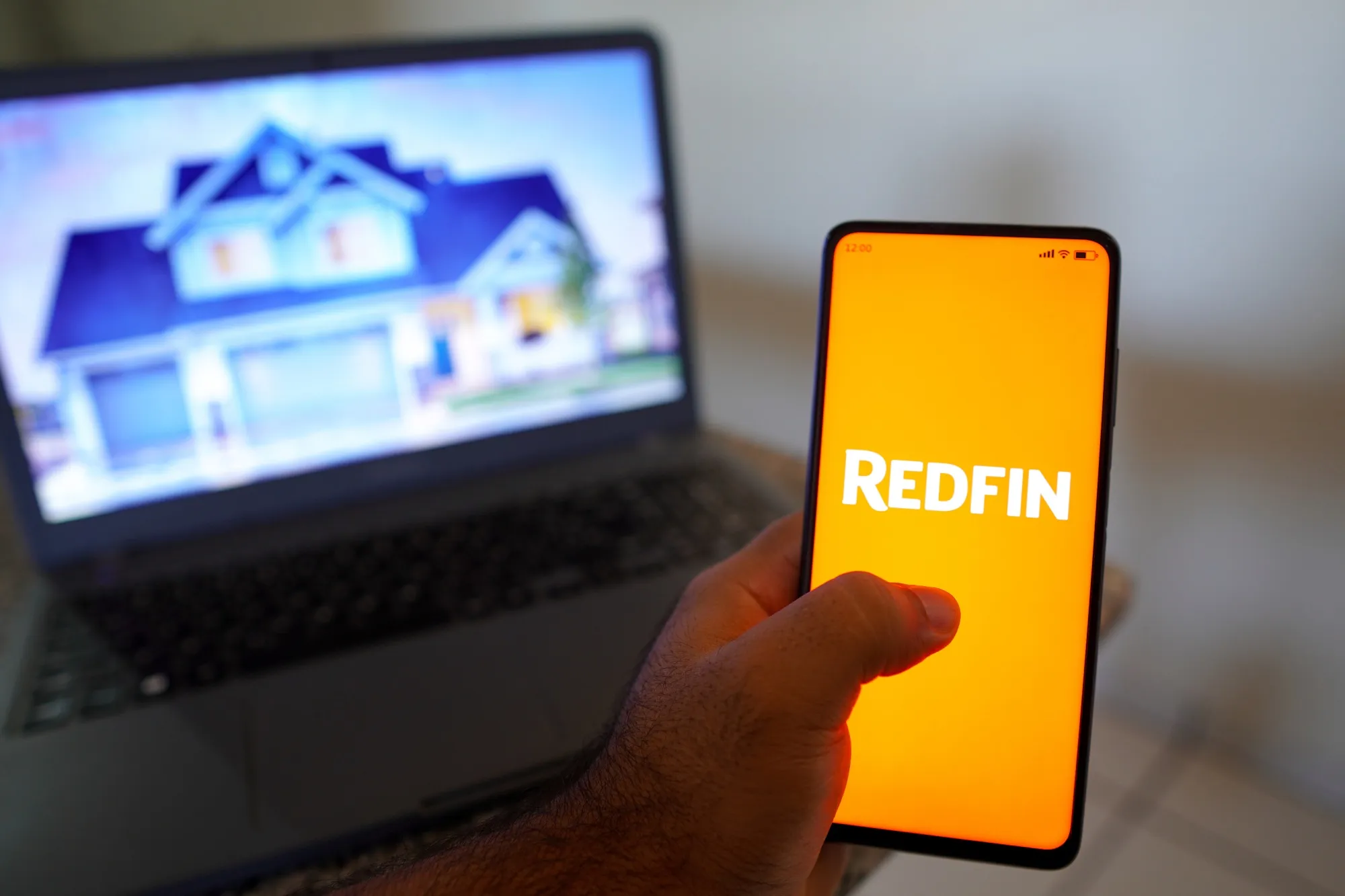 In this photo illustration, the Redfin logo seen displayed