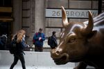 Pedestrians pass the Charging Bull statue near the New York Stock Exchange (NYSE) in New York, U.S., on Friday, March 9, 2018. U.S. stocks rose while Treasuries fell as the latest labor report showed the American economy continued to strengthen without the prior month's rapid wage gains that stoked inflation fears.
