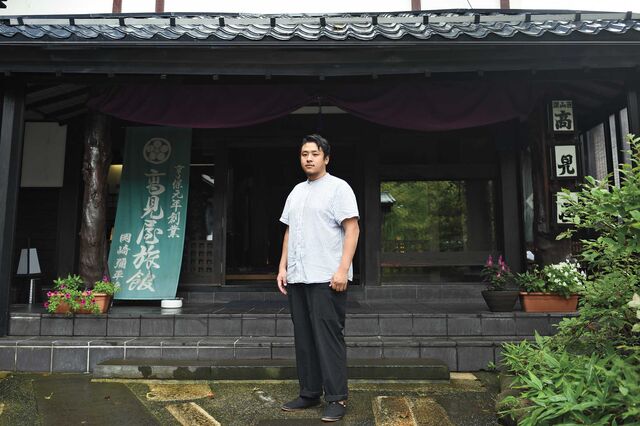 高見屋旅館の前に立つ岡崎博門さん
