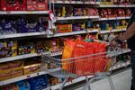 A shopper pushes a cart inside a supermarket in London.