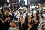 Demonstrators put hands over their hearts during a protest in the Causeway Bay district of Hong Kong.