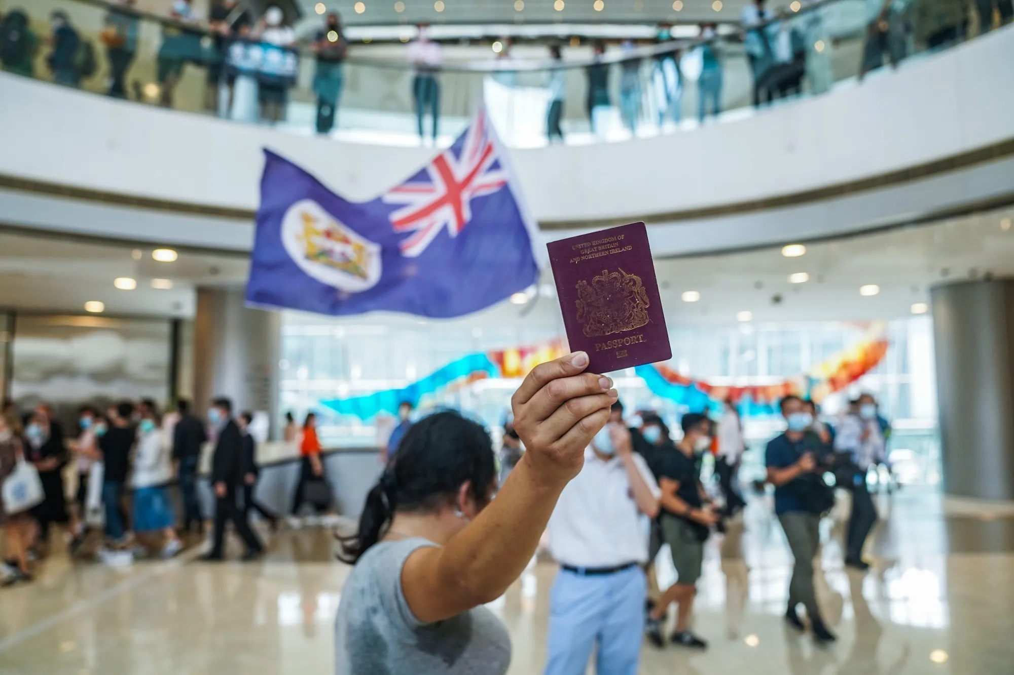 A demonstrator shows a British National (Overseas) passport as another waves a colonial-era Hong Kong flag during a protest&nbsp;in Hong Kong, China, on&nbsp;May 29.