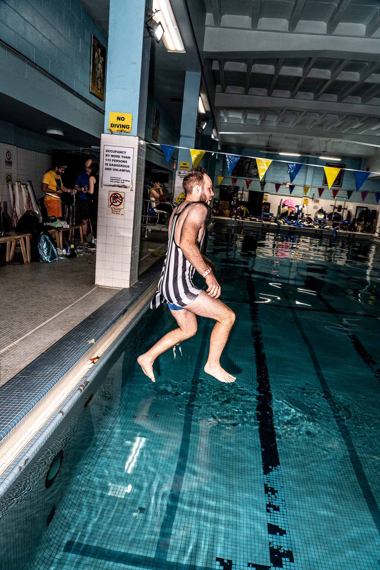A contestant prepares to unlock an underwater chest at a Lower East Side pool.