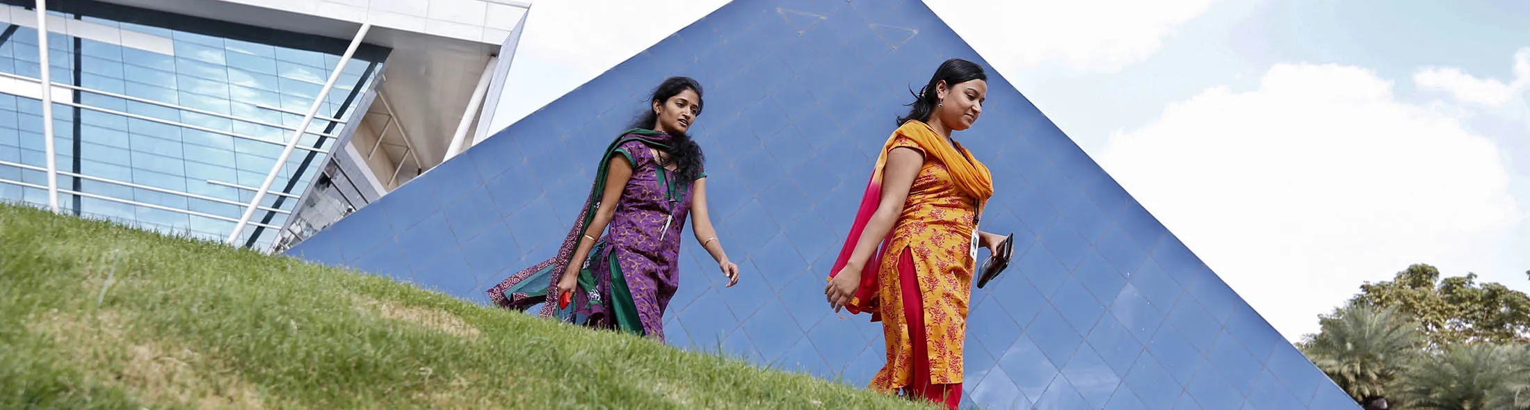 Employees walk in front of the "Pyramid" building at the campus of Infosys Ltd. at the Electronics City area in Bangalore, India, on Monday, January 27, 2014.
