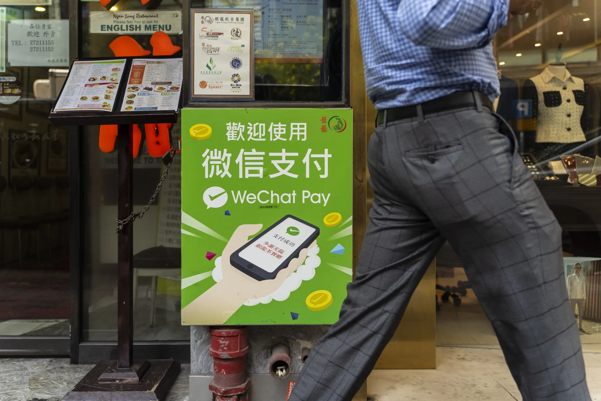 An advertisement for Tencent Holdings Ltd.'s WeChat Pay digital payment service is displayed outside a restaurant in Hong Kong, China, on Tuesday, Sept. 1, 2020. WeChat Pay and Ant Group's Alipay account for the majority of the mobile payments transactions in China.