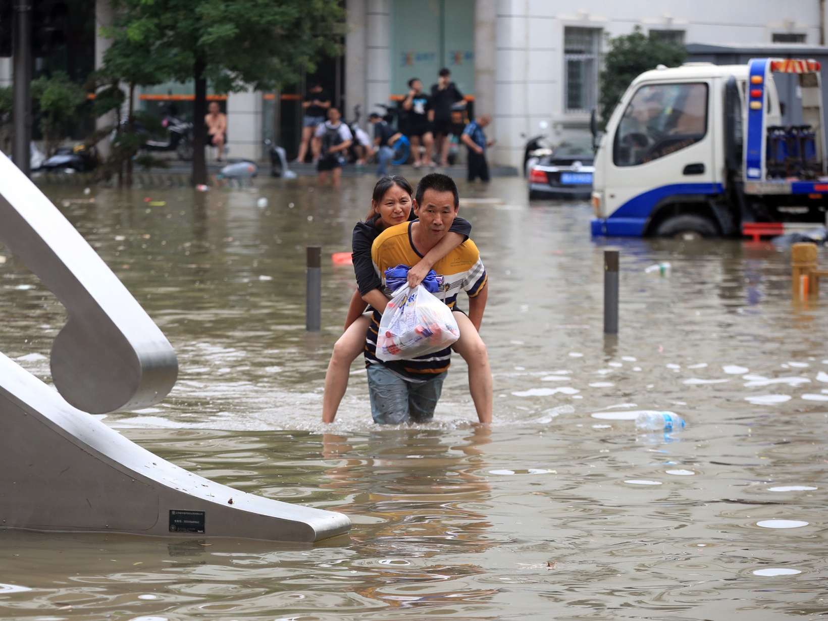 People walk through floodwaters in Zhengzhou, China on&nbsp;July 21.&nbsp;