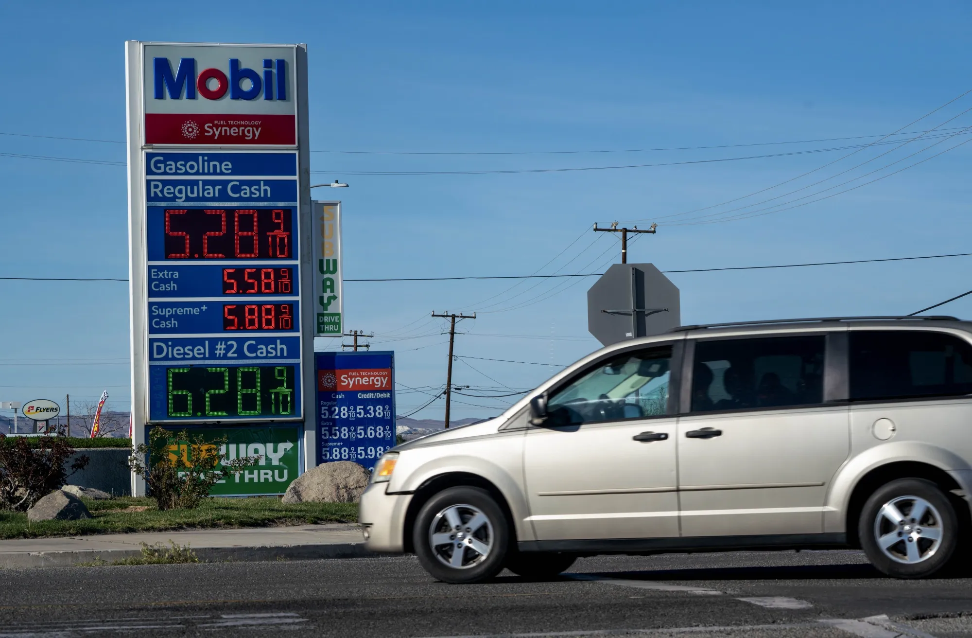 A sign displays the prices of unleaded gasoline and diesel fuel at a Chevron gas station in California