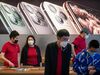 Apple staff (red t-shirt) and a customer (R) wearing protective facemasks are seen inside of an Apple store in Beijing on January 30, 2020. 