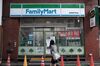 A pedestrian walks past a closed FamilyMart Co. convenience store in the Asakusa district of Tokyo, Japan.