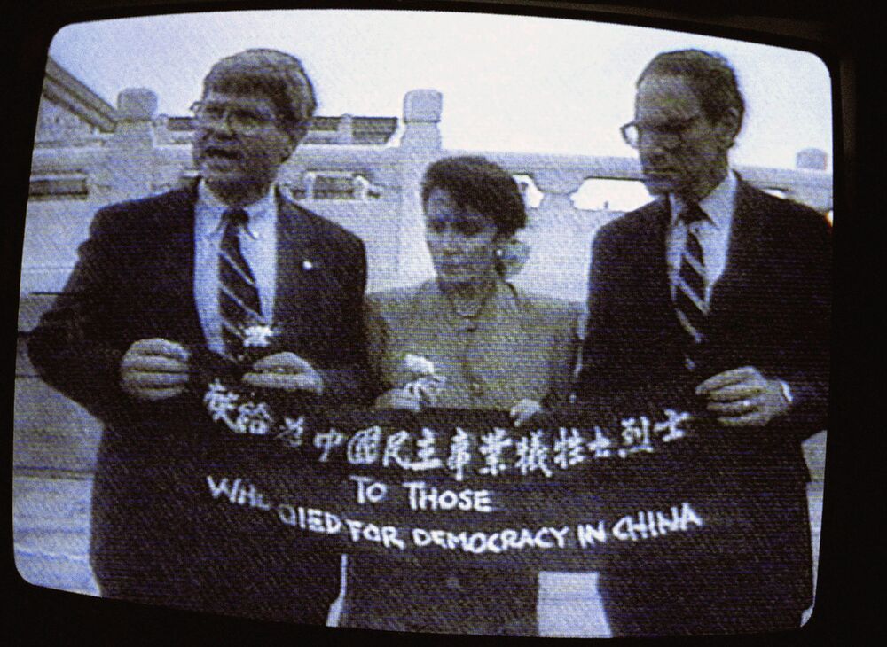 Una imagen de televisión de Nancy Pelosi, centro, sosteniendo una pancarta con otros miembros del Congreso en Beijing en septiembre de 1991.