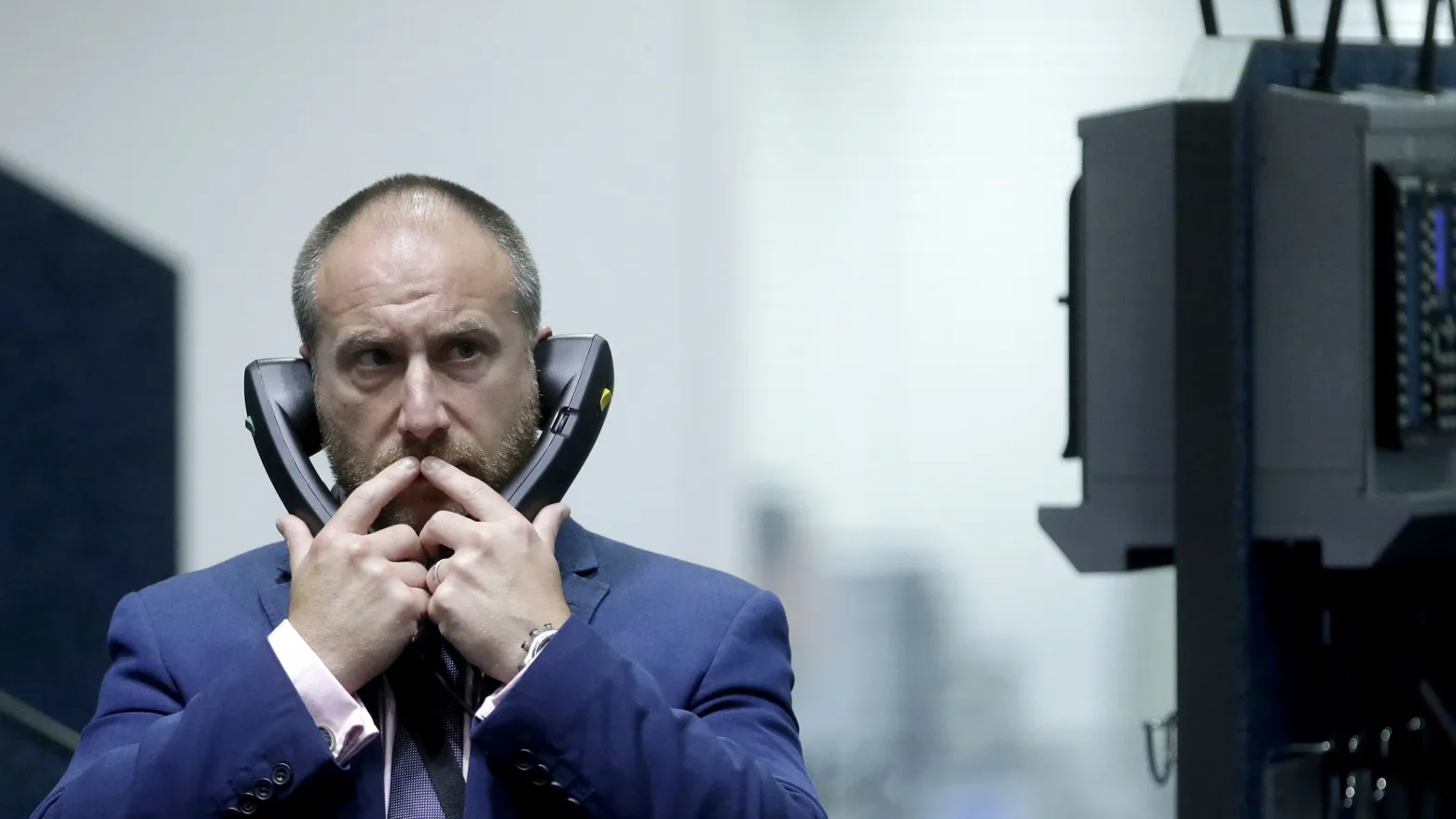 A traders uses telephones as he works from the pit at the London Metal Exchange.
