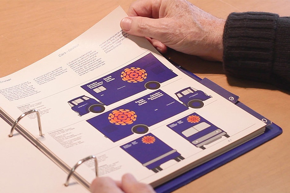 Graphic designer Burton Kramer thumbs through the pages of the CBC standards manual he created.