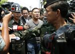Watana Muangsook is escorted by military officers as he arrives at a military base in Bangkok in April 2016.