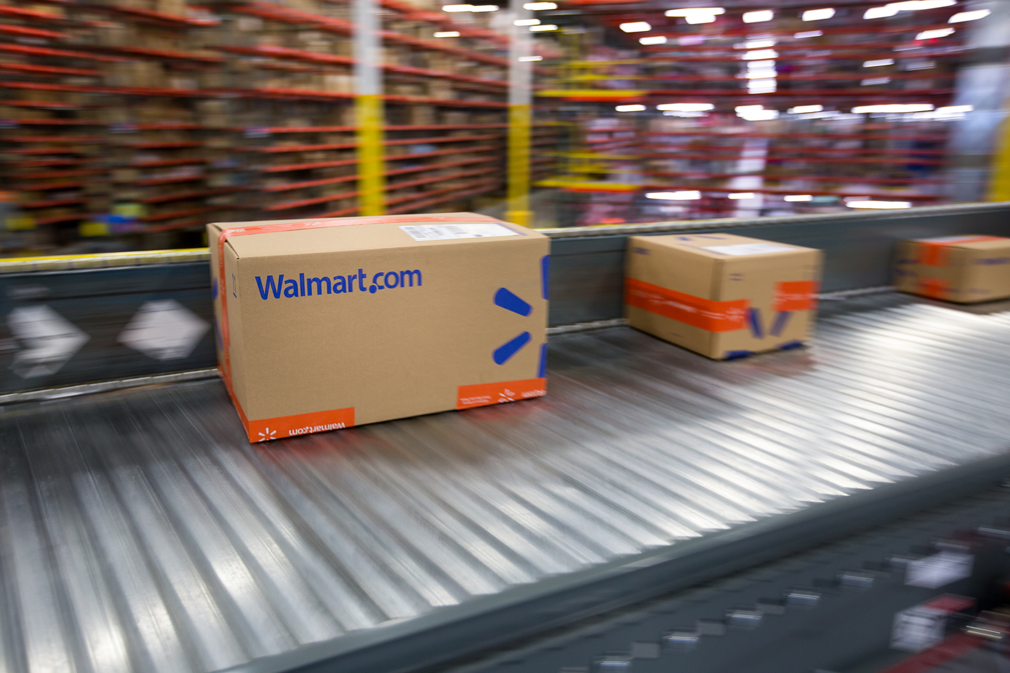 Packages move along a conveyor belt inside a Wal-Mart Stores Inc. fulfillment center in Bethlehem, Pennsylvania, U.S., on Wednesday, March 29, 2017.
