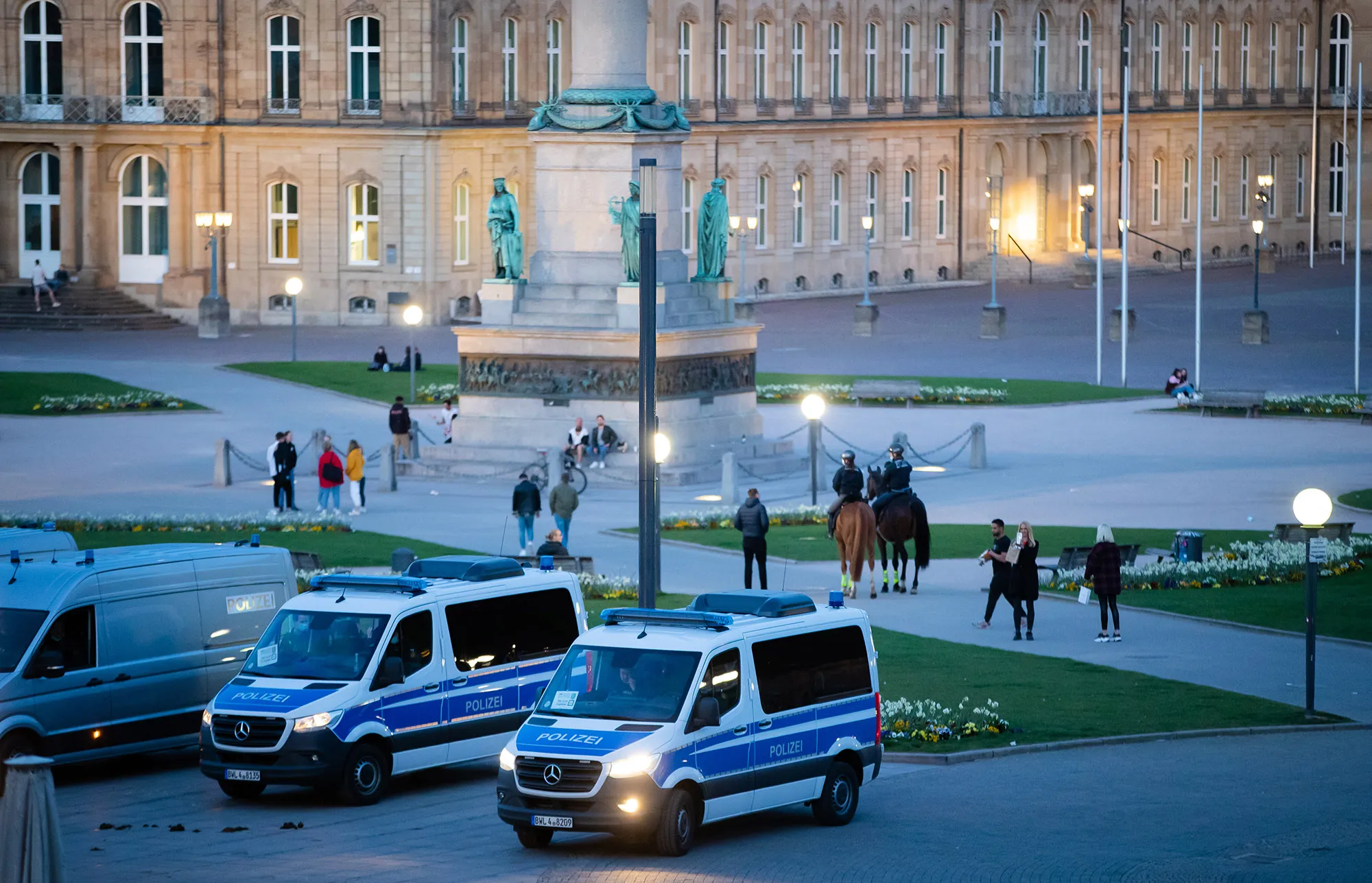 Police cars stand in the Schlossplatz shortly before the curfew begins, in Suttgart on April 23.&nbsp;