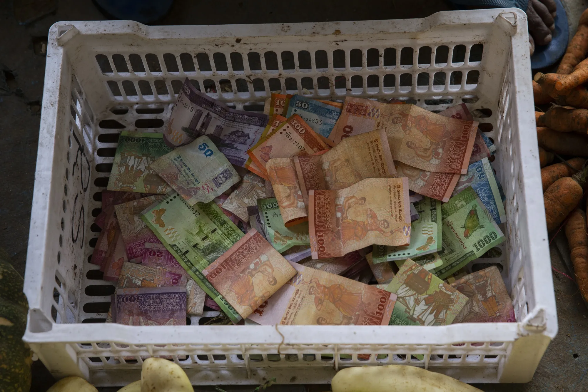 Sri Lankan bank notes in a container at a vegetable stall in Colombo.