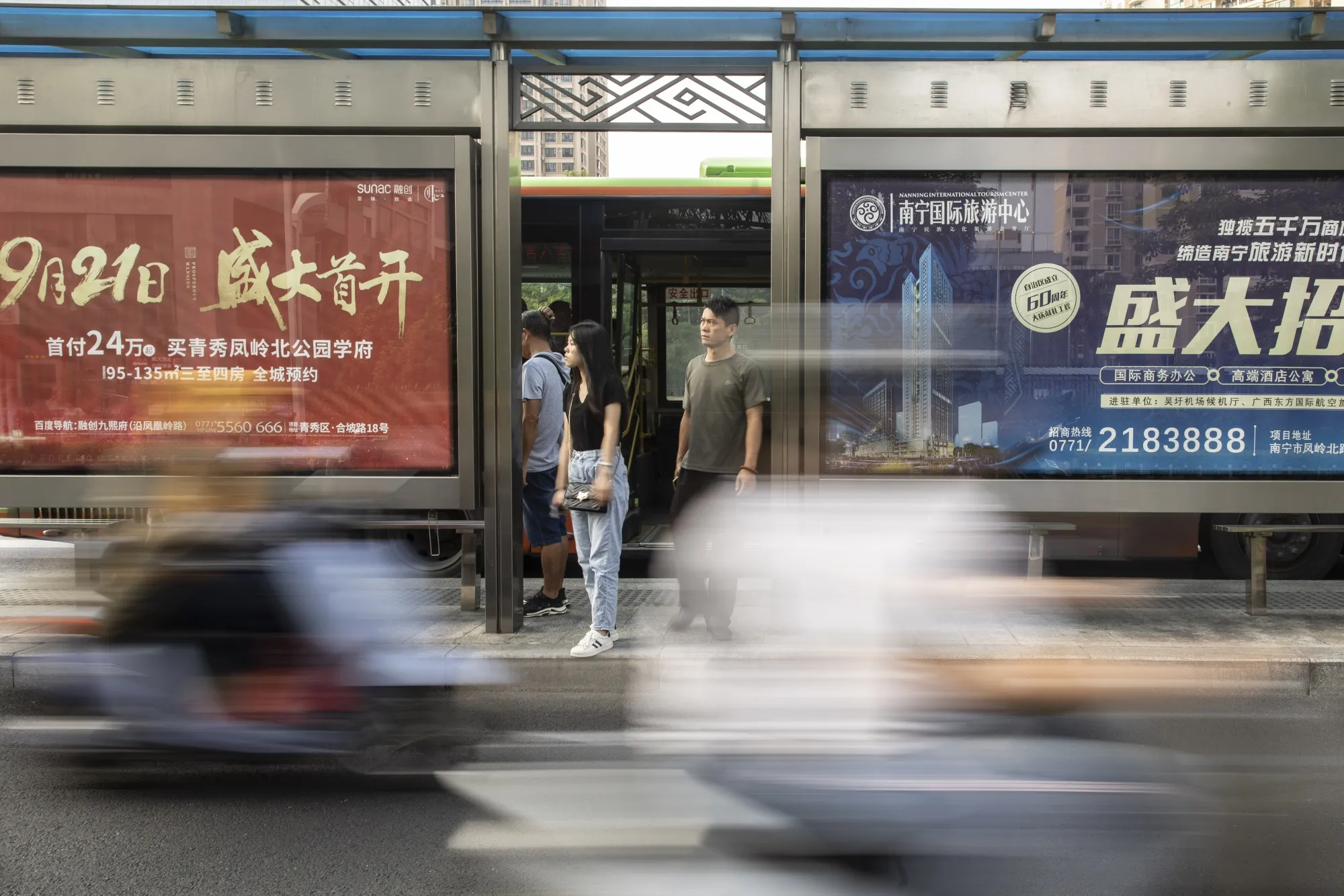 Pedestrians wait at a bus stop during rush hour in Nanning, China.