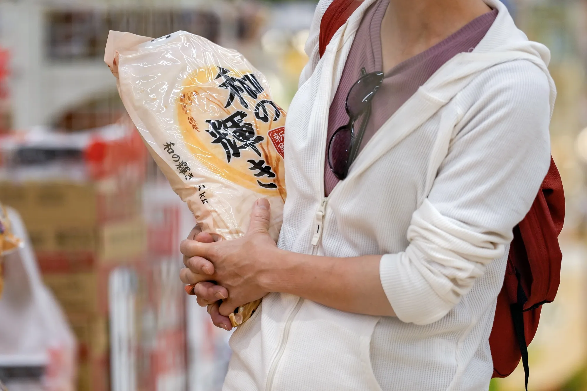 A customer holds a bag of government stockpiled rice at a Unidy store in Matsudo, Chiba Prefecture.