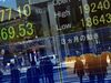 Pedestrians are reflected in a window showing a quotation board displaying the numbers on the Tokyo Stock Exchange in Tokyo on March 26, 2020. - Tokyo's key Nikkei index opened down more than three percent on March 26 on profit-taking after surging in recent sessions, although US stimulus plans offset worries over the COVID-19 coronavirus pandemic. (Photo by Kazuhiro NOGI / AFP) (Photo by KAZUHIRO NOGI/AFP via Getty Images)