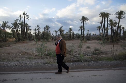 Jean-Yves Ollivier uses a mobile phone as he walks along a road near his property in Marrakesh, Morocco, on Dec. 1, 2014.