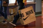 A customer walks with a Nike shopping bag through the Great Lakes Crossing Outlets mall in Auburn Hills, Michigan, U.S., on Saturday, Oct. 30, 2021.