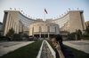 A man talks on a mobile phone outside the People's Bank of China headquarters in Beijing, China, on Monday, Oct. 23, 2017. China's central bank is said to have gauged demand for 63-day reverse repurchase agreements for the first time ever.