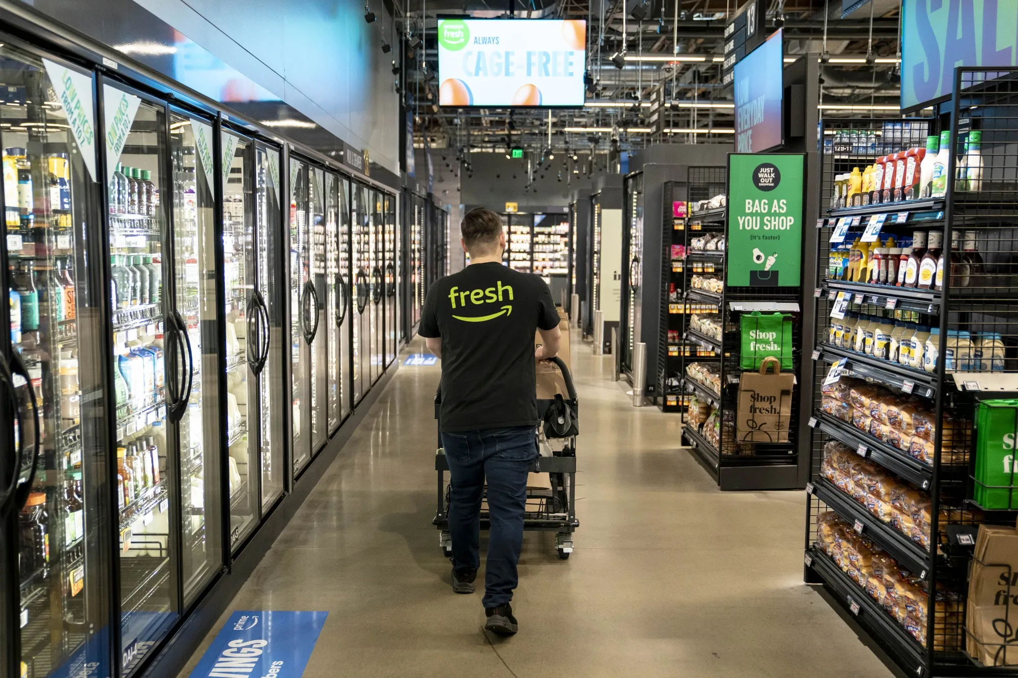 A worker picks up customer orders at an Amazon Fresh grocery store in Seattle, Washington.