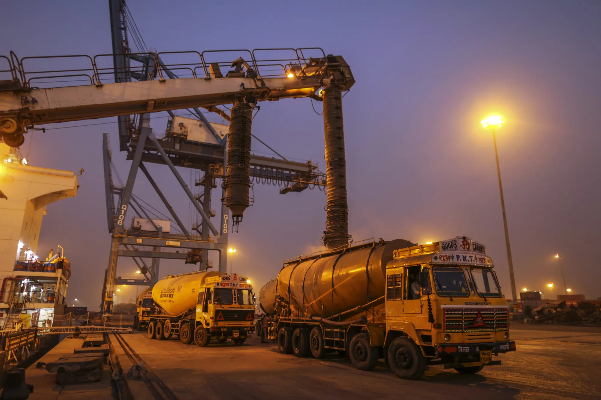 Cement tanker trucks are filled from a ship at the Jawaharlal Nehru Port in Navi Mumbai, India.