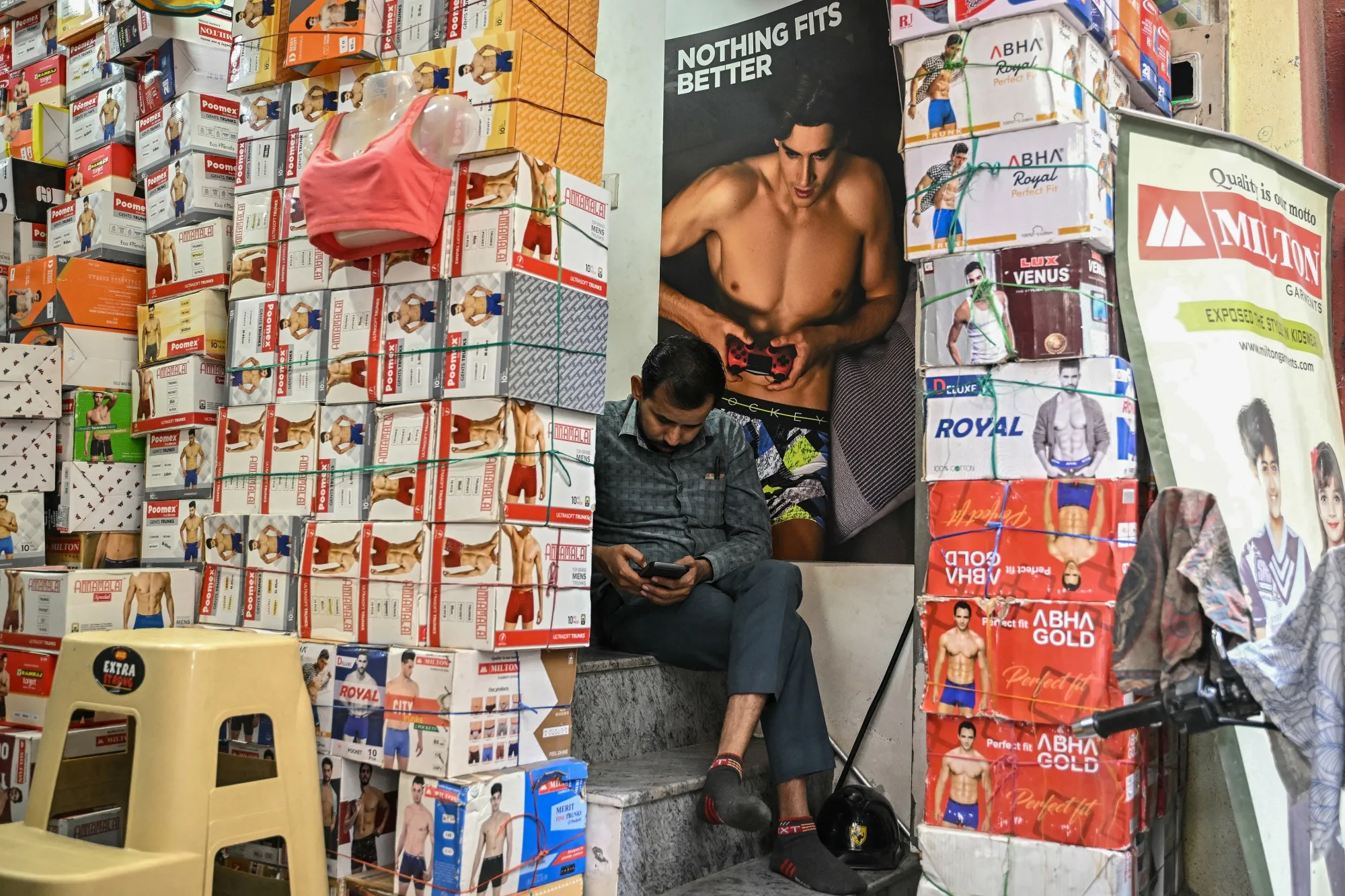 A vendor uses a mobile phone while waiting for customers at a market in Bengaluru.