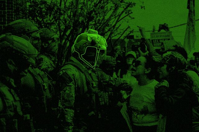 Immigration officials in military gear are confronted by protesters 