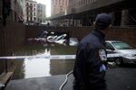 A police officer looks towards vehicles submerged in water in the Financial District of New York on Oct. 30, 2012.