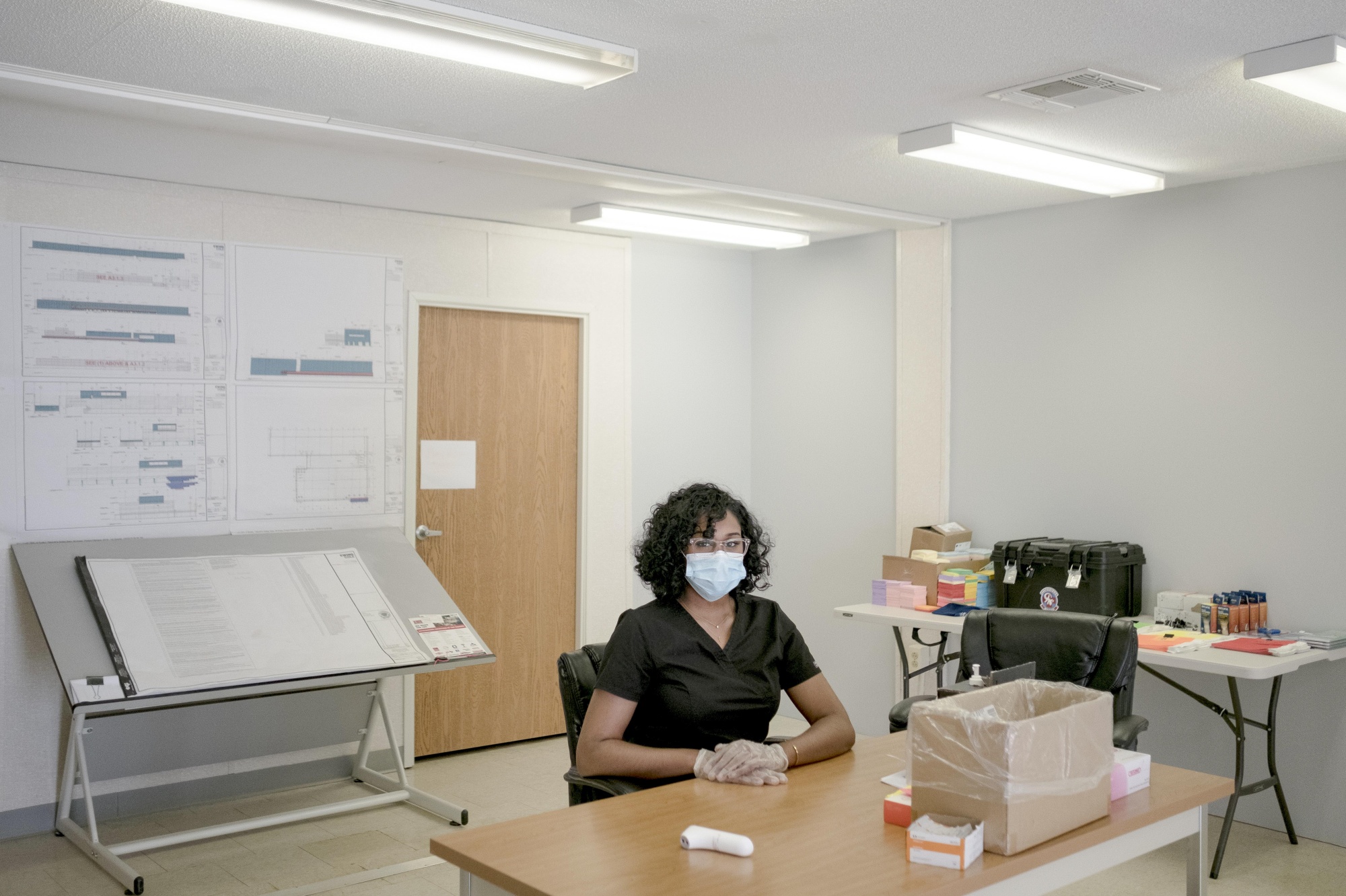 Simone Williams, a thermal scanner for Covid-19, sits for a photograph in the trailer of a construction site in Urbana, Maryland.