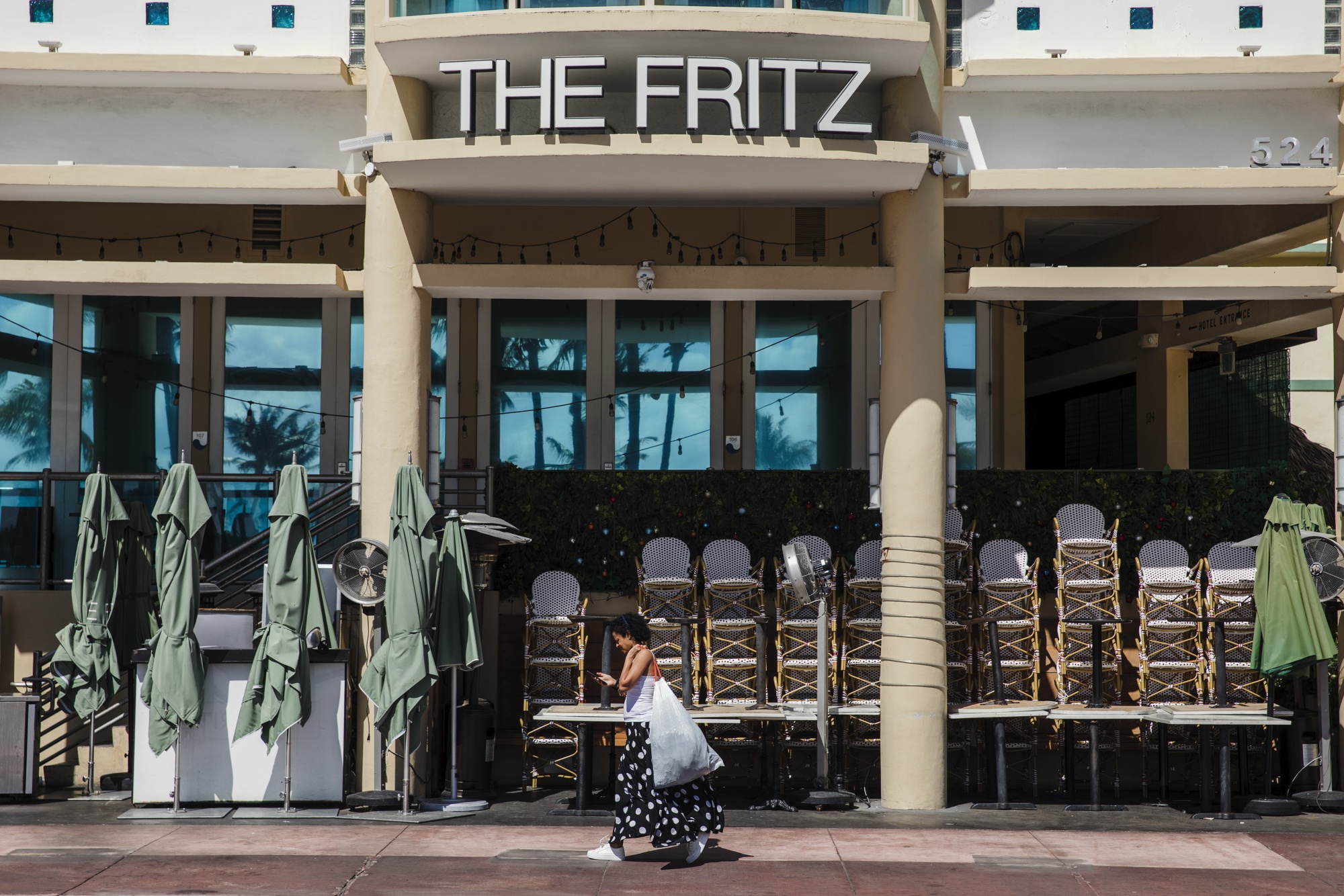 Seorang pejalan kaki melewati restoran tertutup di South Beach, Florida, A.S.