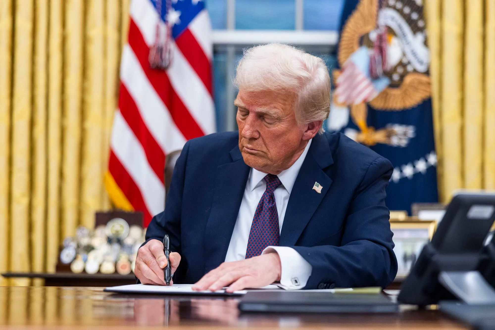 Donald Trump signs executive orders in the Oval Office of the White House in Washington, DC, on Jan. 20.
