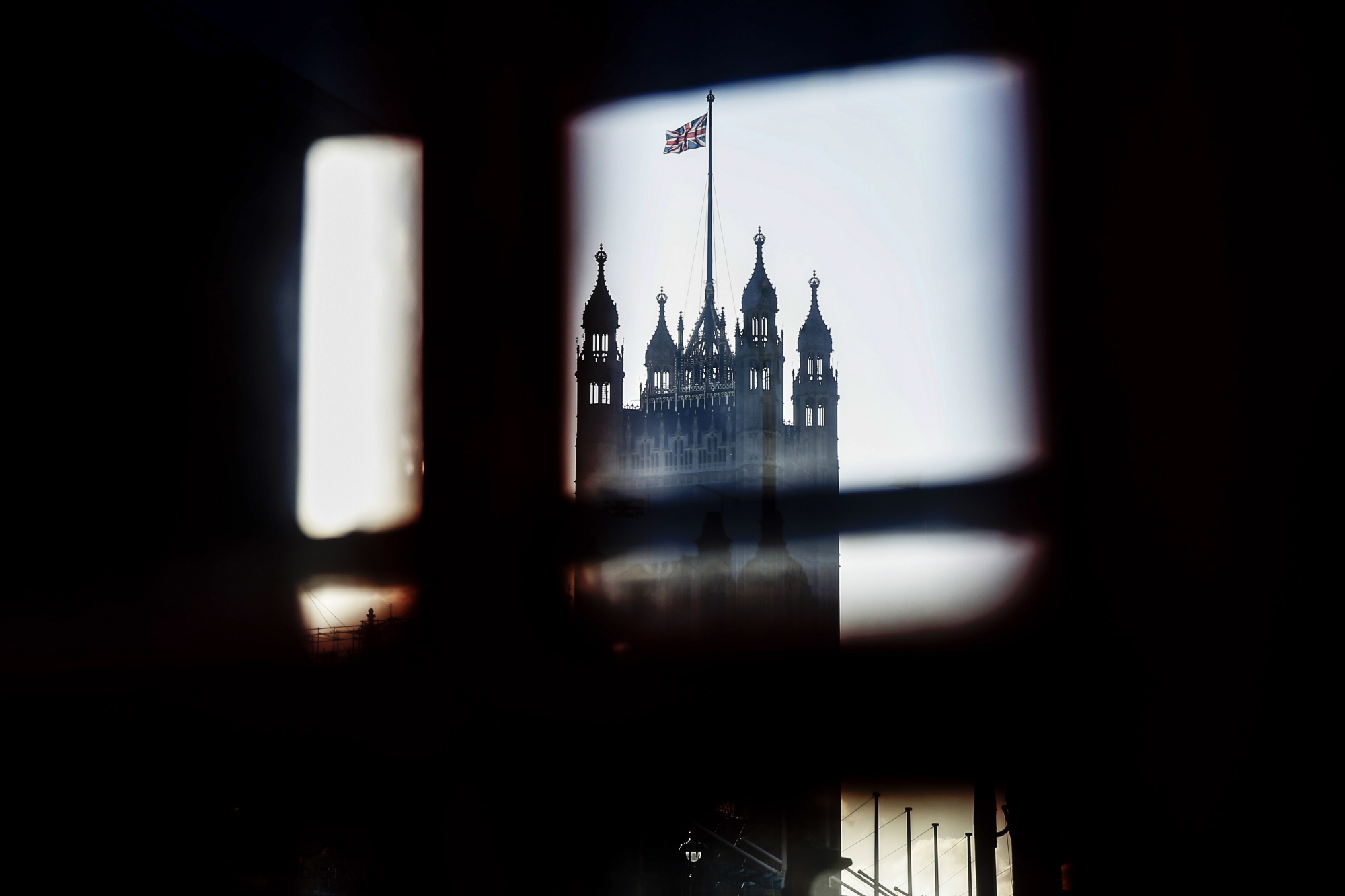 Window panes in a telephone box frame a view of the Victoria tower, part of the Houses of Parliament, in London.