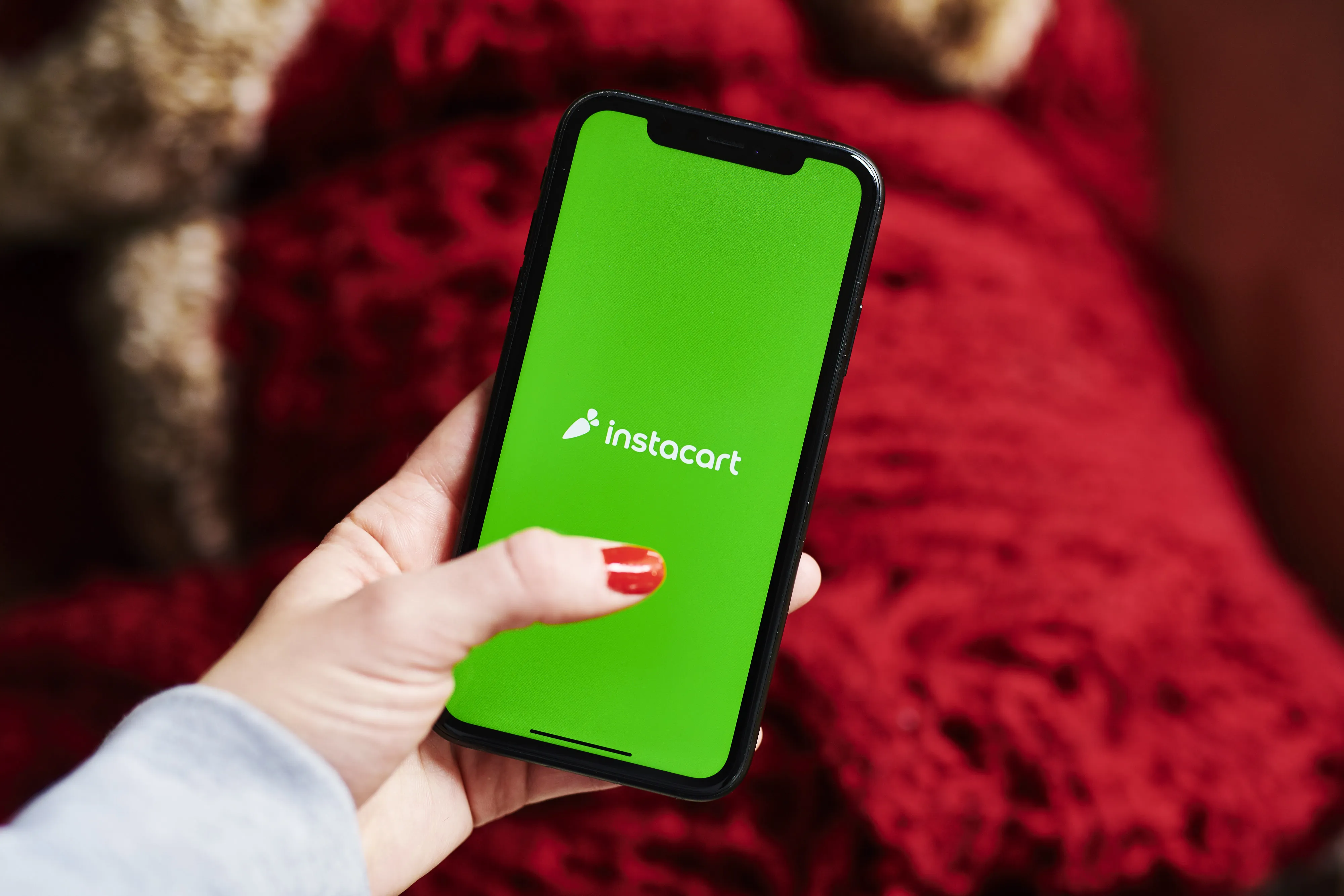The logo for the Instacart application is displayed on an Apple Inc. iPhone.