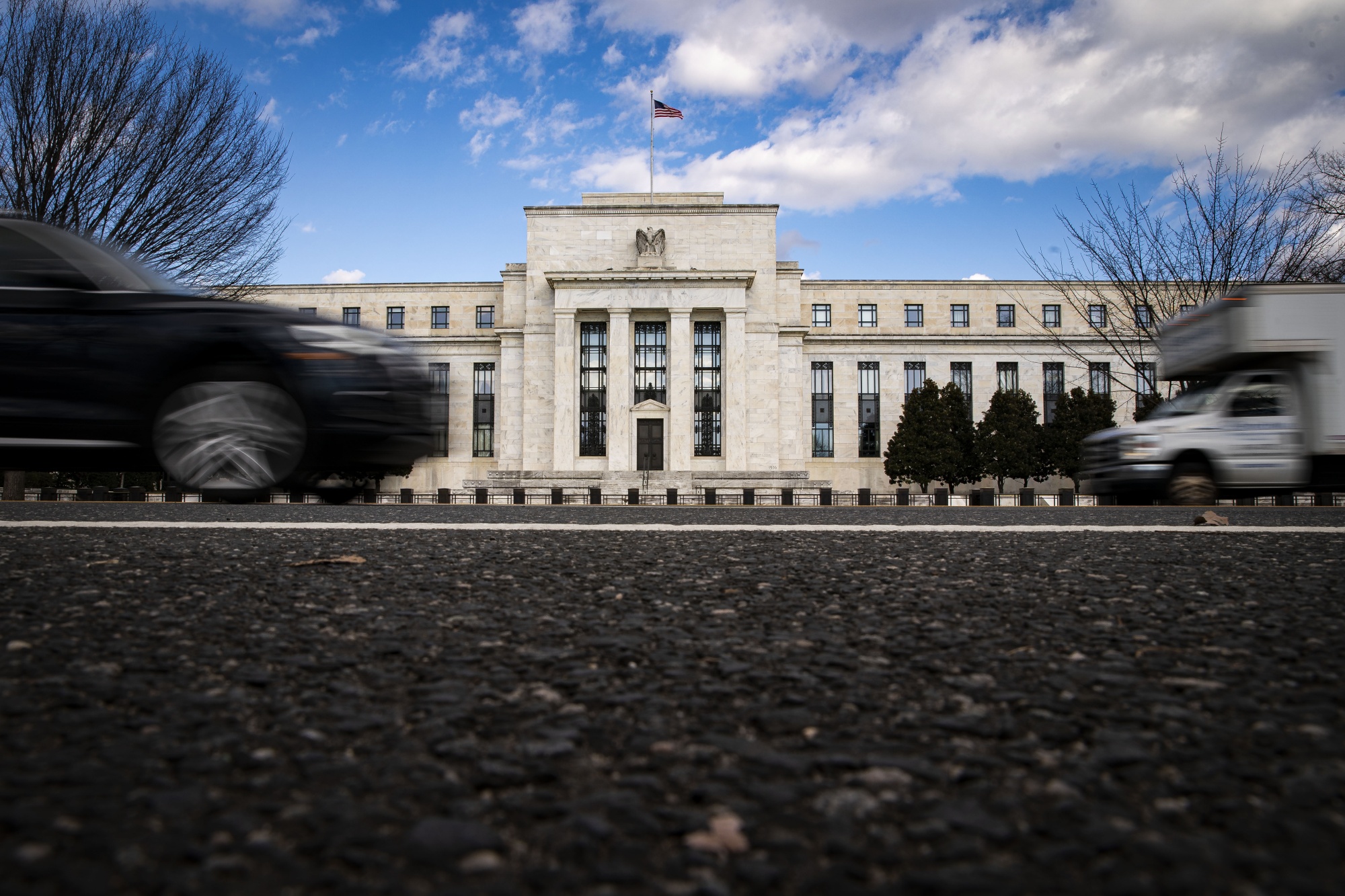 Vehicles pass in front of the Marriner S. Eccles Federal Reserve building in Washington, DC.