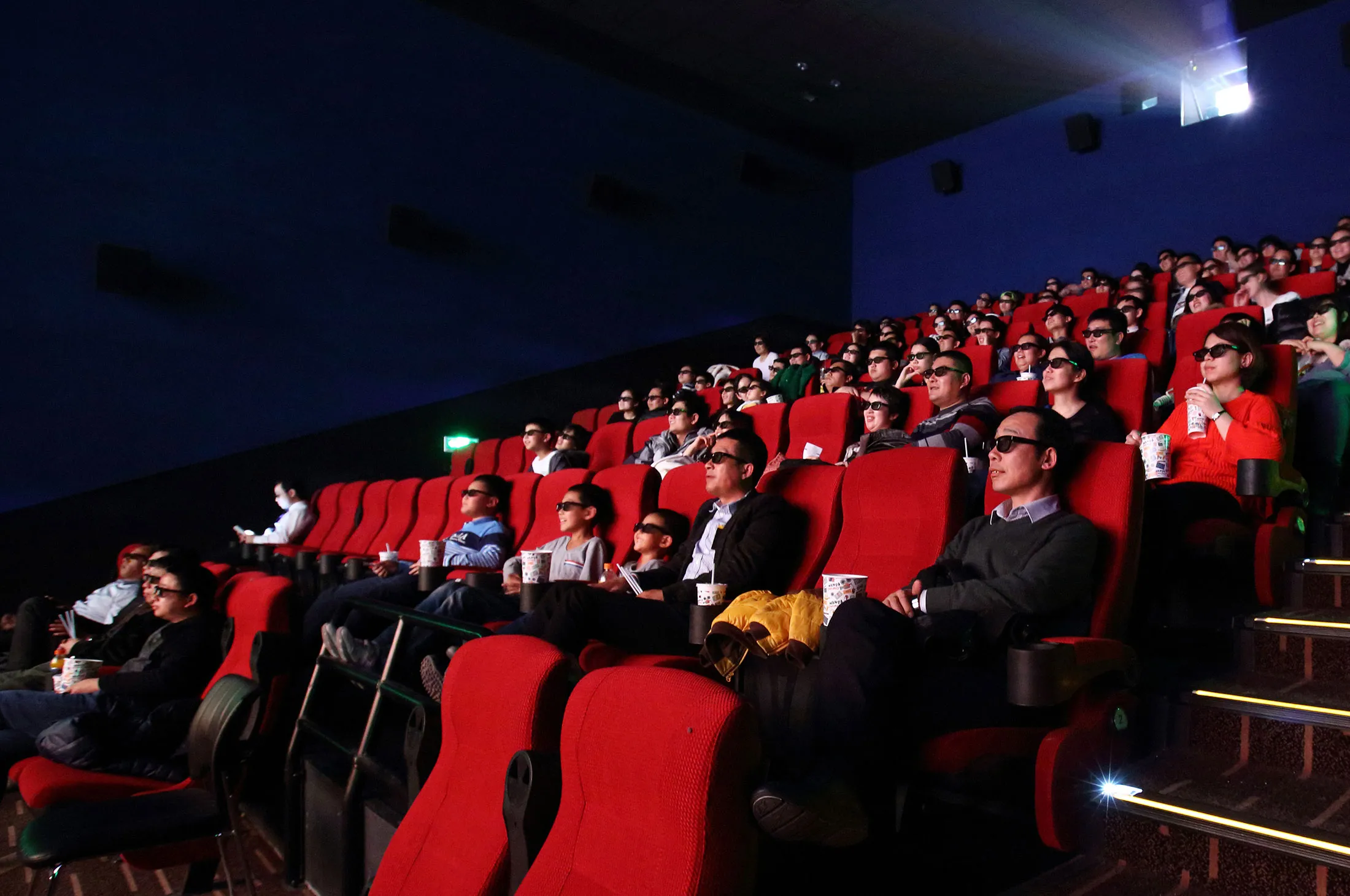 People wear 3-D glasses while watch a movie in the Wanda Cinema Line Co. cinema at the Tongzhou Wanda Plaza shopping mall.
