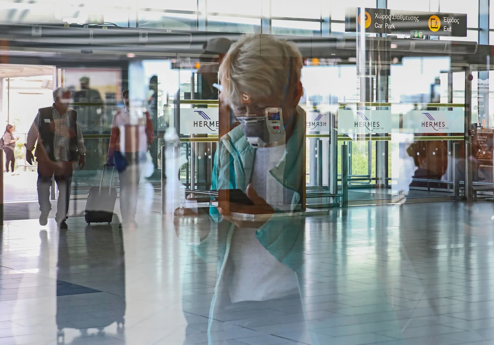 A masked passenger arrives at Larnaca International Airport.