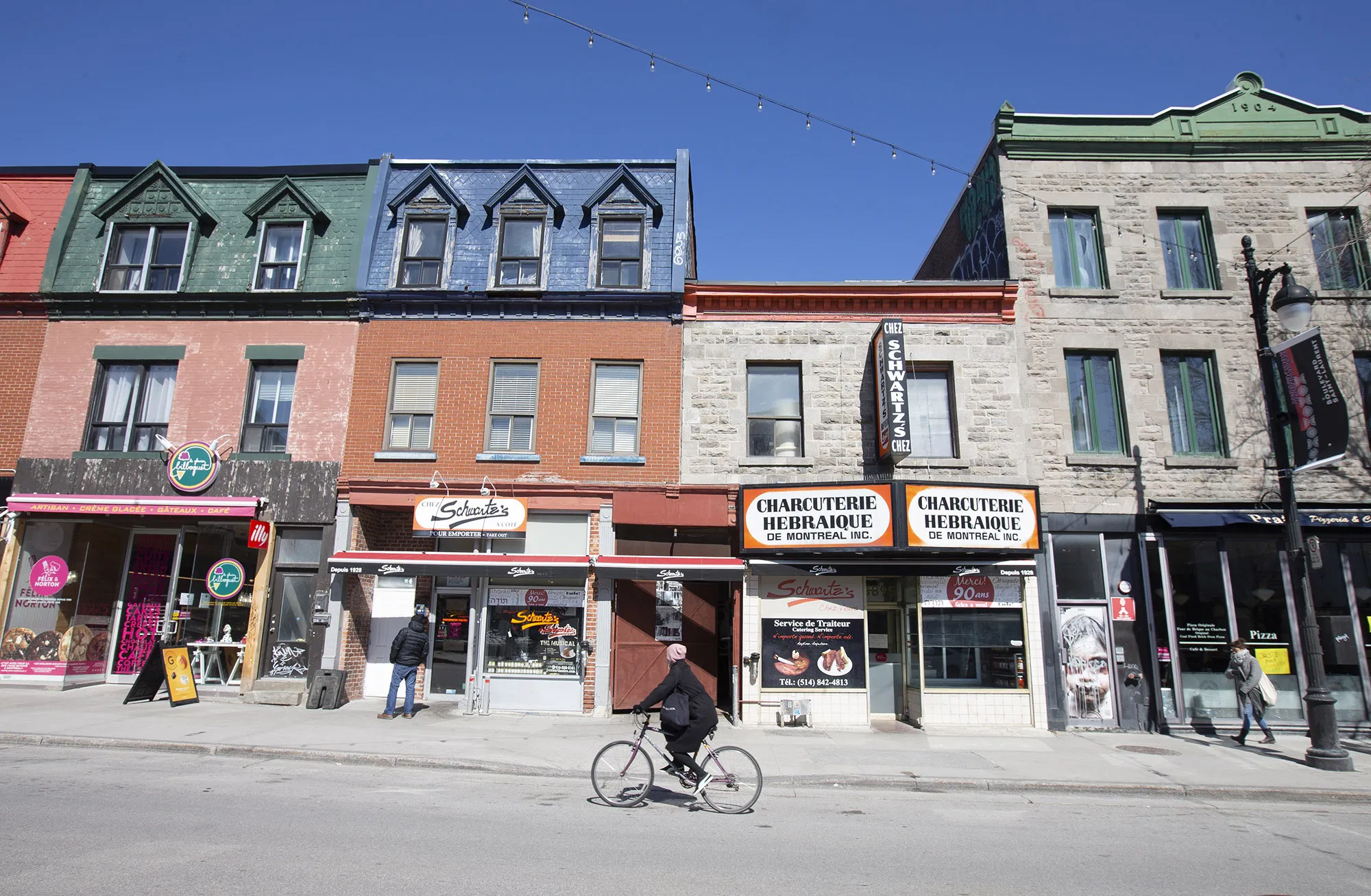 A cyclist rides along a street of small businesses&nbsp;in Montreal, Quebec, Canada.