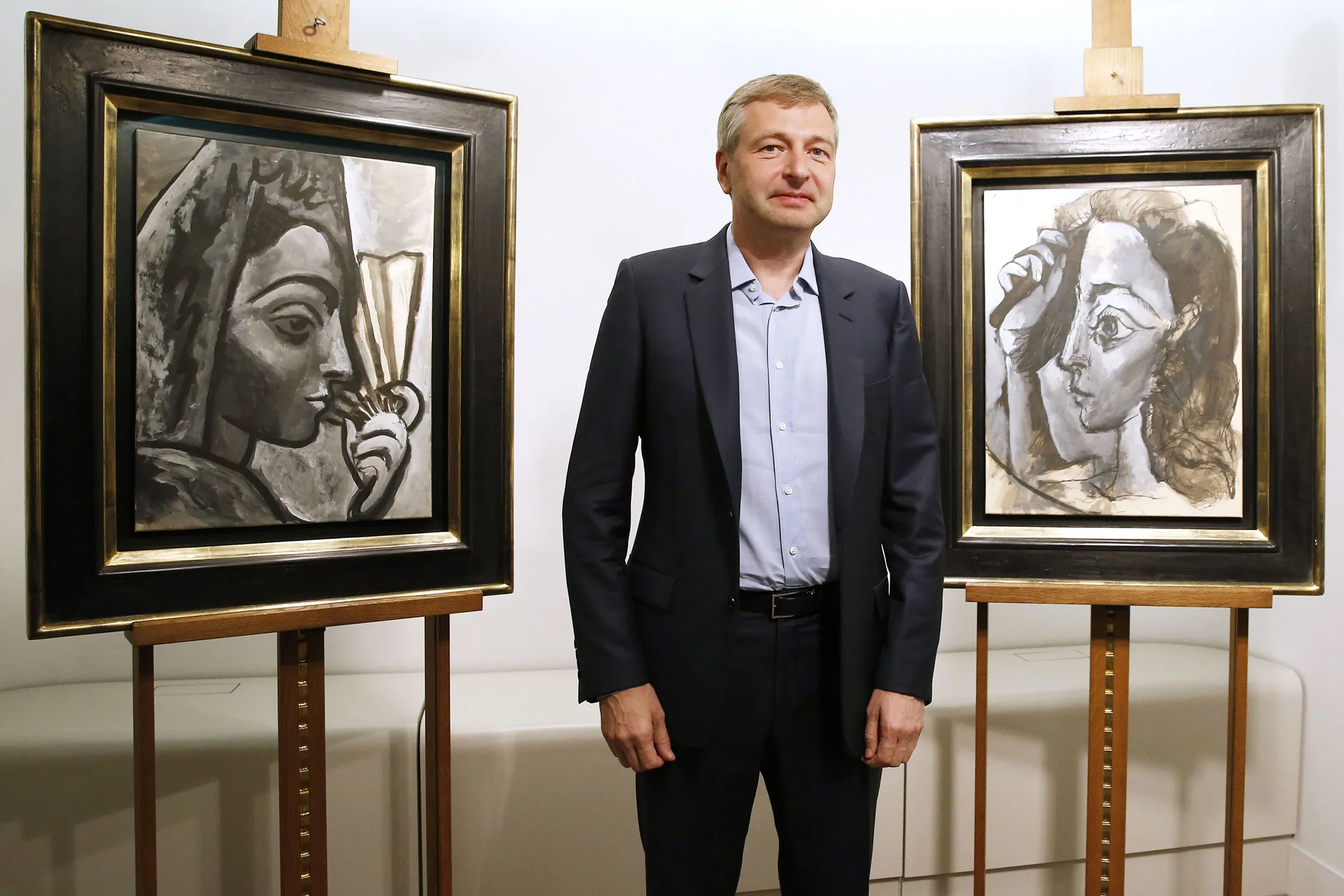 Dmitry Rybolovlev poses in Paris in front of two allegedly stolen paintings by Pablo Picasso, which he purchased from a Swiss art dealer.

